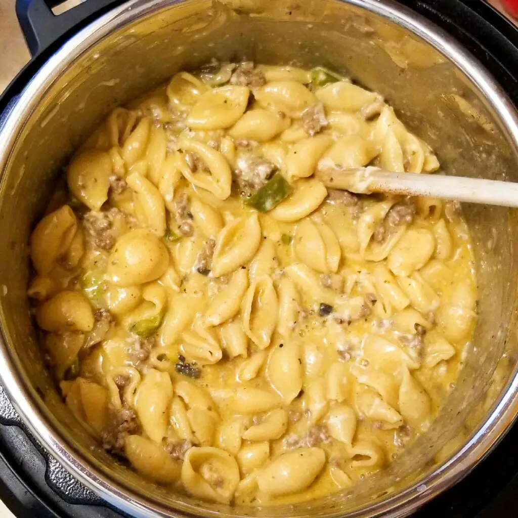 Adding the sour cream and cheese to cheesesteak pasta and letting it sit so the cheese melts before serving