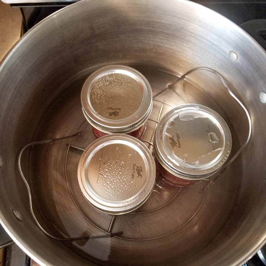 Jars of jam after processing in the bottom of the stock pot