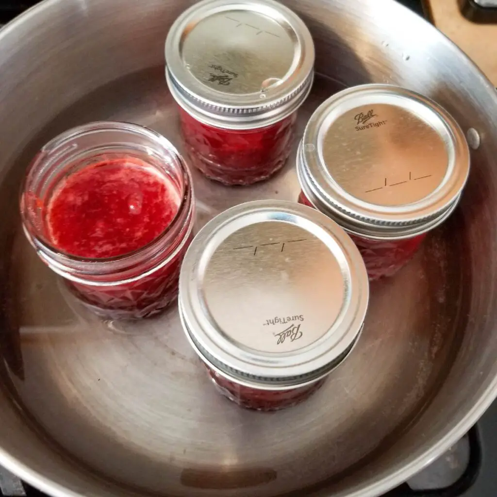 pouring jam into jars for canning