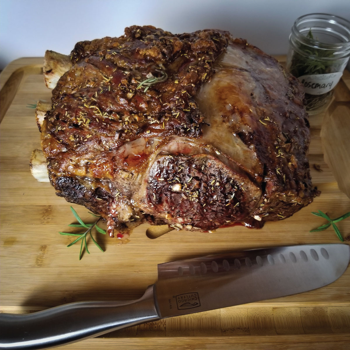 Rib roast sitting on a cutting board with a knife ready to be cut.