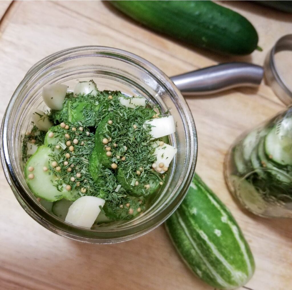 Adding the spices to the top of the cucumbers before adding the brine