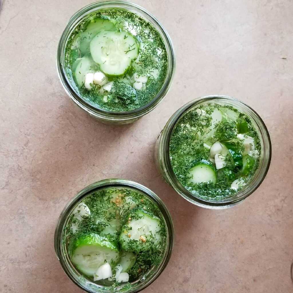 Adding the brine to the cucumbers close to the top and completely covering cucumbers