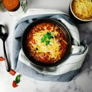 Stuffed pepper soup in a serving bowl topped with cheese.