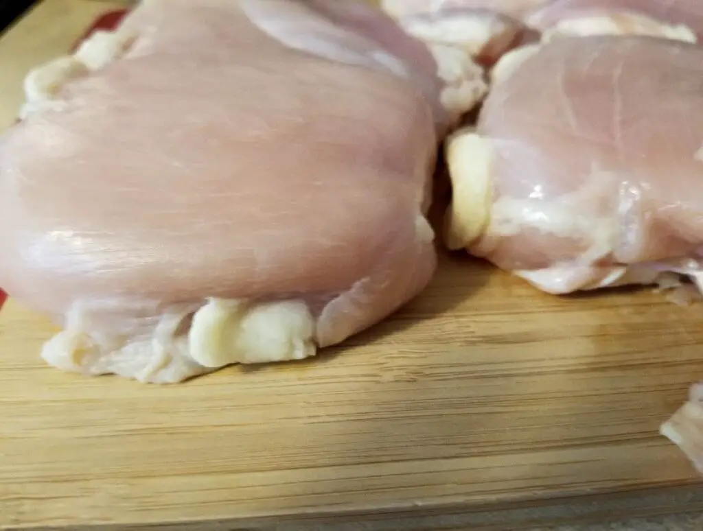 chicken on a cutting board pounded down to the same thickness for even cooking