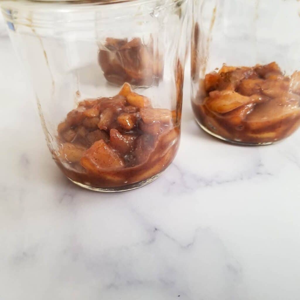 apple filling divided evenly among 3 jars ready for yogurt