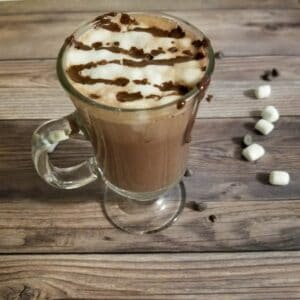 Hot chocolate in a cup with marshmallow froth and drizzled chocolate