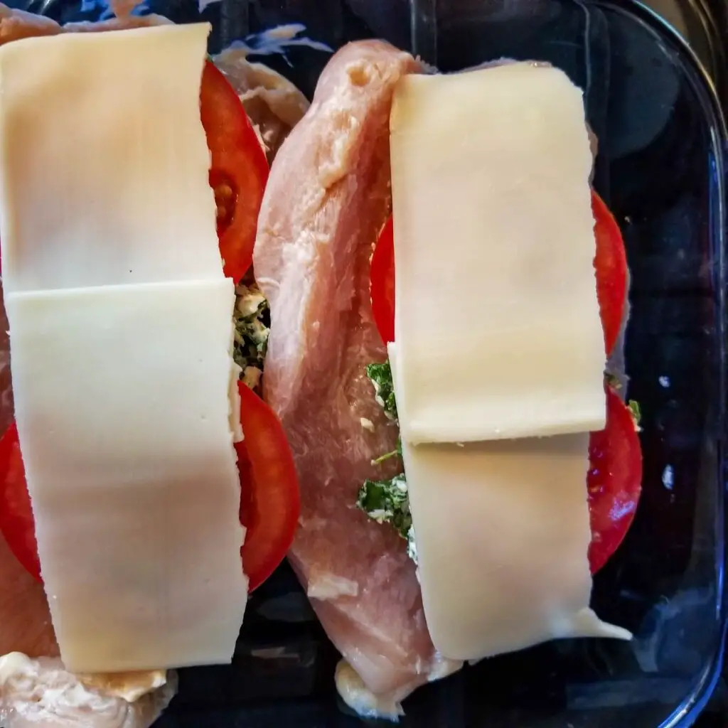 Chicken cut sliced lengthwise and filled with cheese, tomatoes and spinach before baking