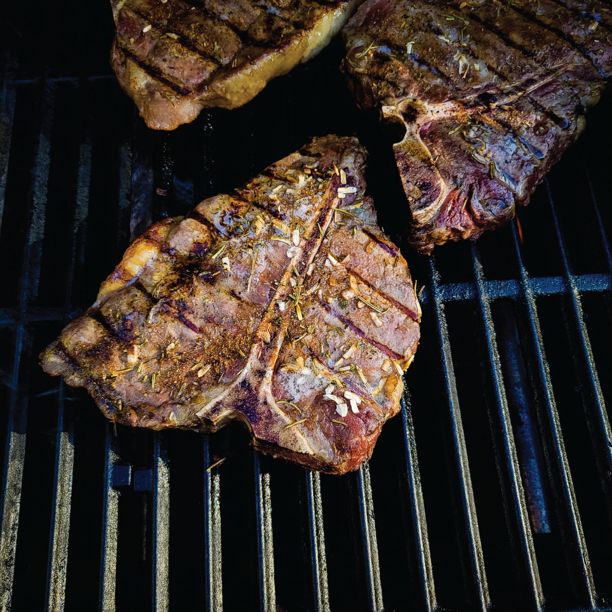 T-bone steaks on the grill after flipping them and almost ready to come off grill.