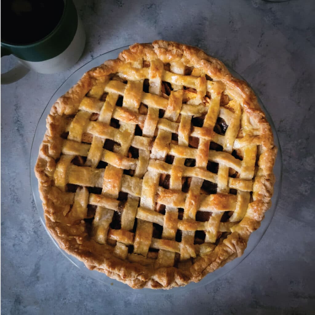 Apple pie with a golden brown crust ready to be cut and served.