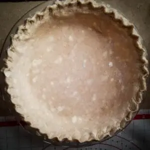 pumpkin pie crust shaped into pie dish ready for filling