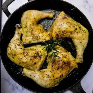 Leg quarters cooked in a skillet ready to be served