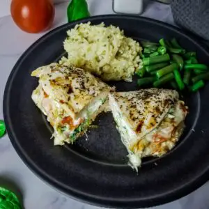 stuffed chicken on a plate with rice and green beans