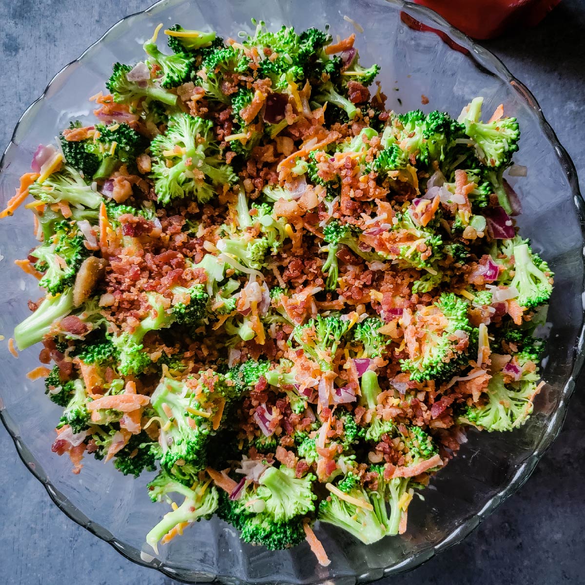 Broccoli salad in a bowl with bacon on top ready to be served.