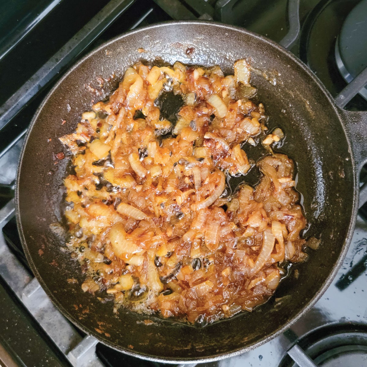 Onions and garlic in a pan after adding the Jack Daniel's