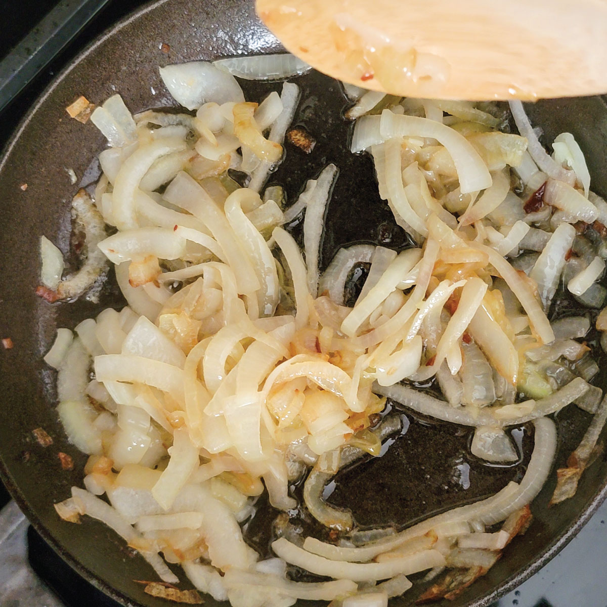 onions in a frying pan with oil just starting to brown