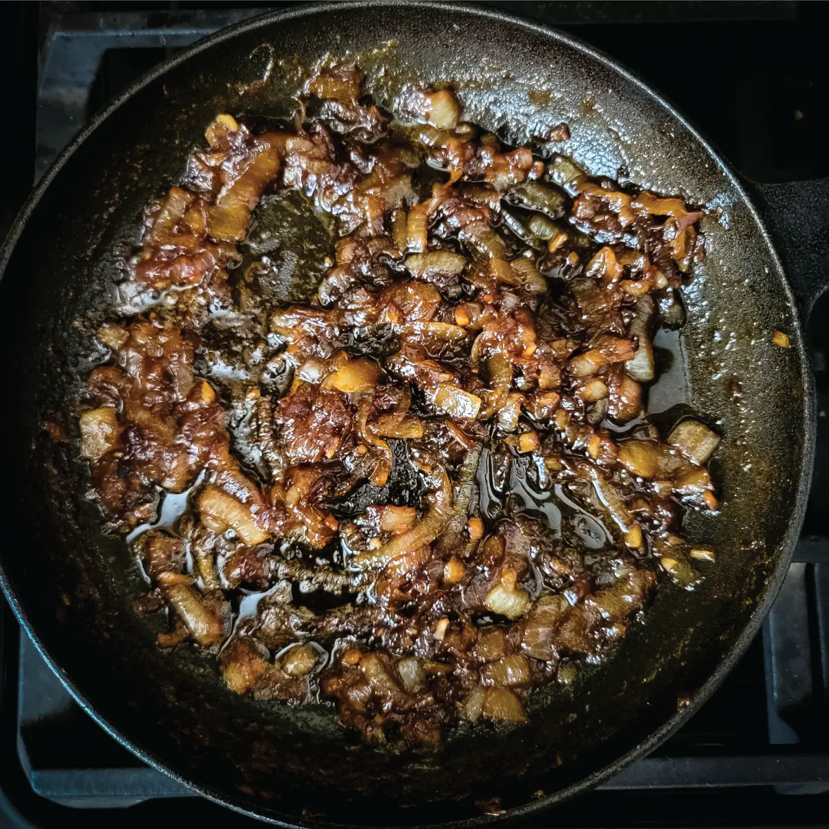 Onions caramelized with Jack Daniel's in a frying pan after removing from heat.