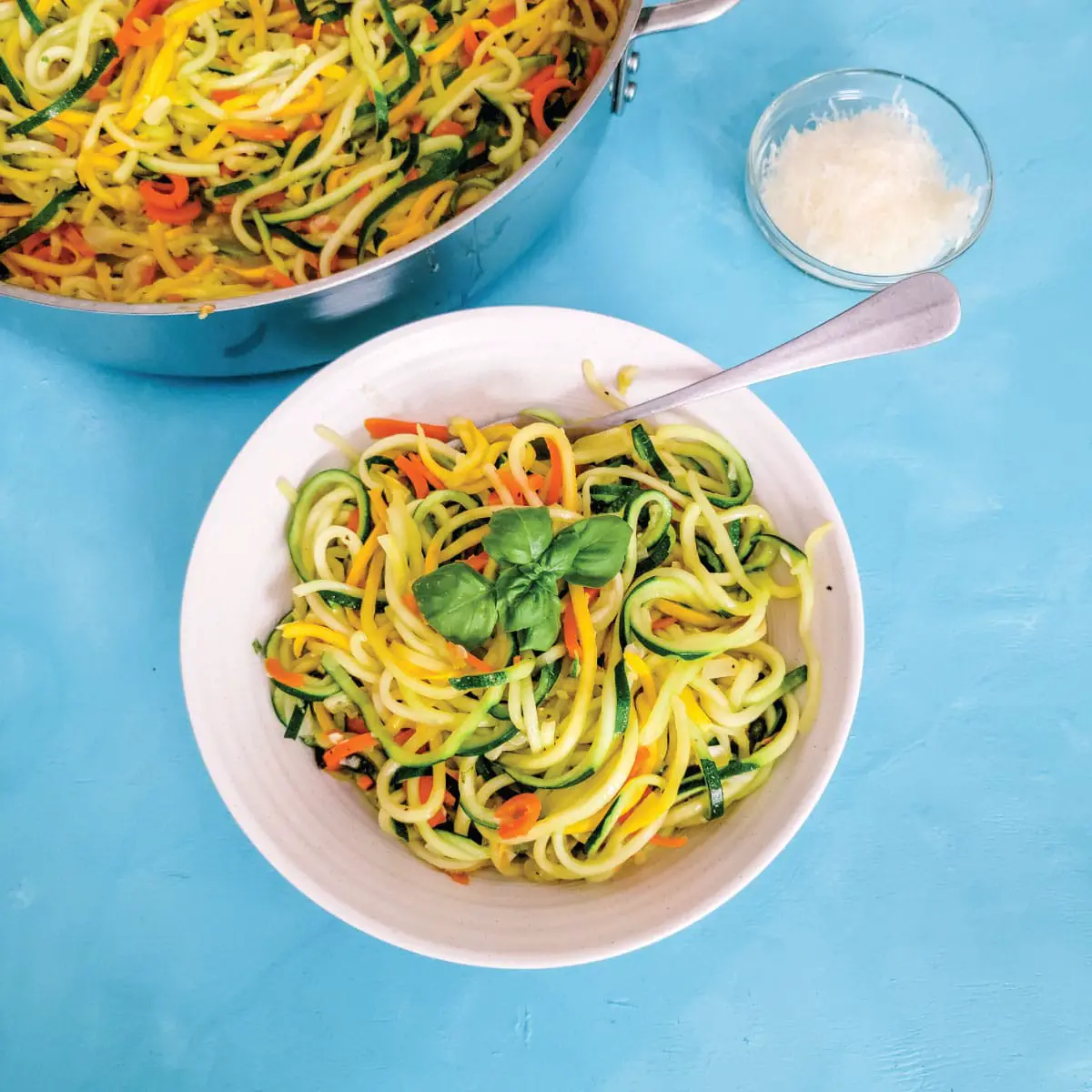 Carrot, squash and zucchini noodles cooked in a garlic sauce in a serving bowl ready to eat