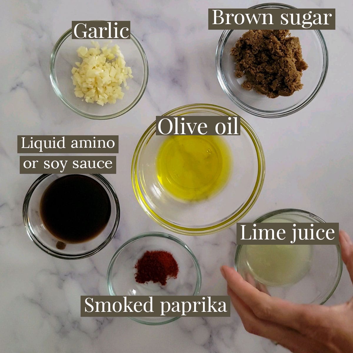 Ingredients for marinade in small prep bowls - garlic, brown sugar, liquid amino, olive oil, smoked paprika and lime juice.