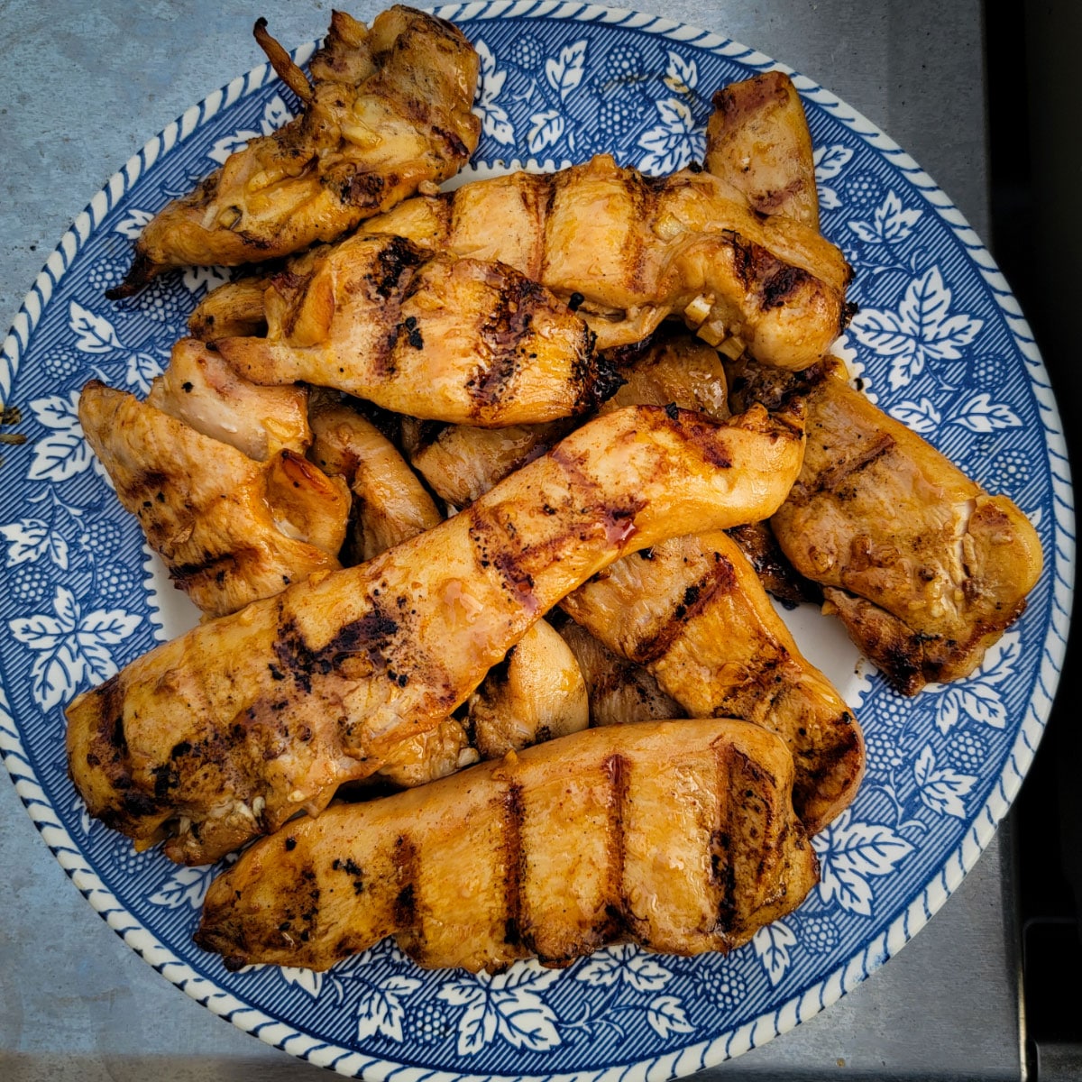 Chicken that was marinated and grilled sitting on a plate ready to serve