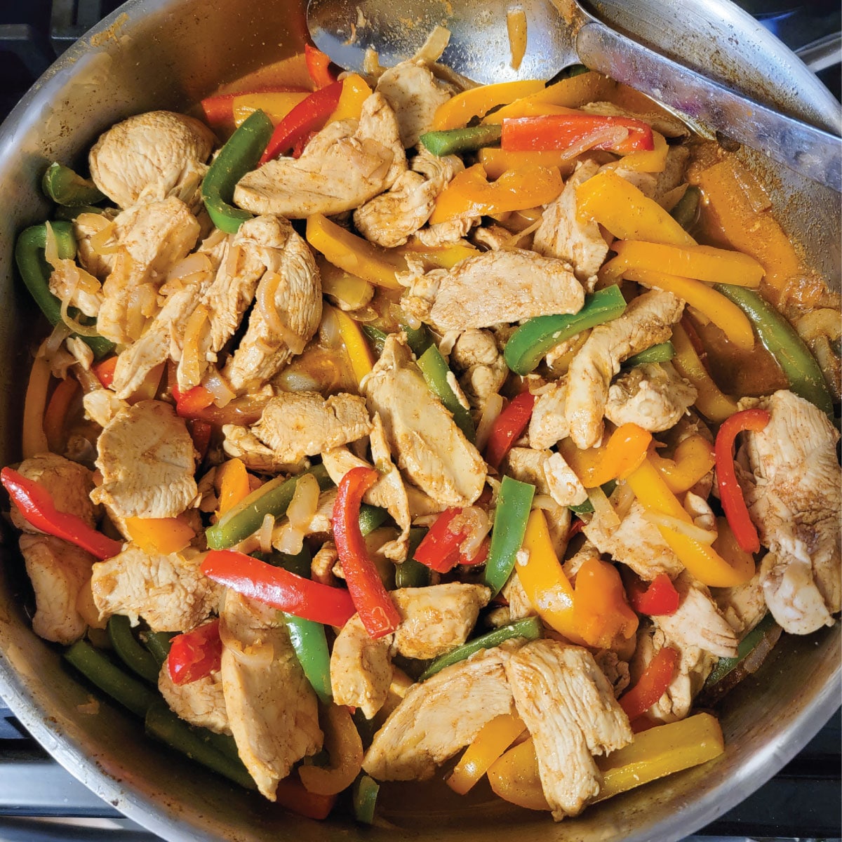 chicken, pepper slices, onion slices and seasoning in a frying pan just before removing from the heat.