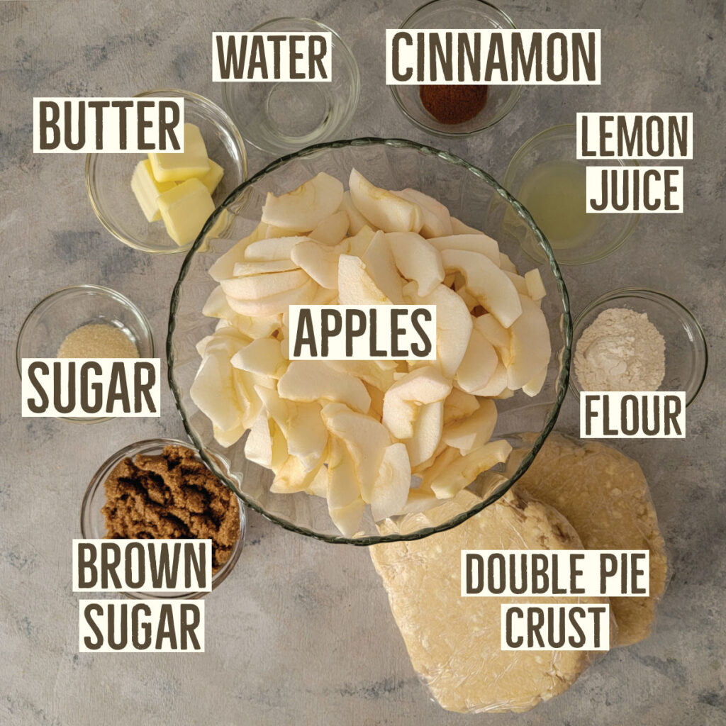 Apple pie ingredients prepped - apples, butter, water, cinnamon, lemon juice, flour, double pie crust, brown sugar and sugar.