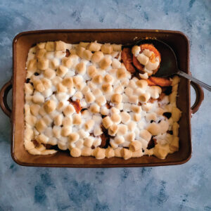 Sweet potato casserole in the baking dish after baking with a golden marshmallow top.