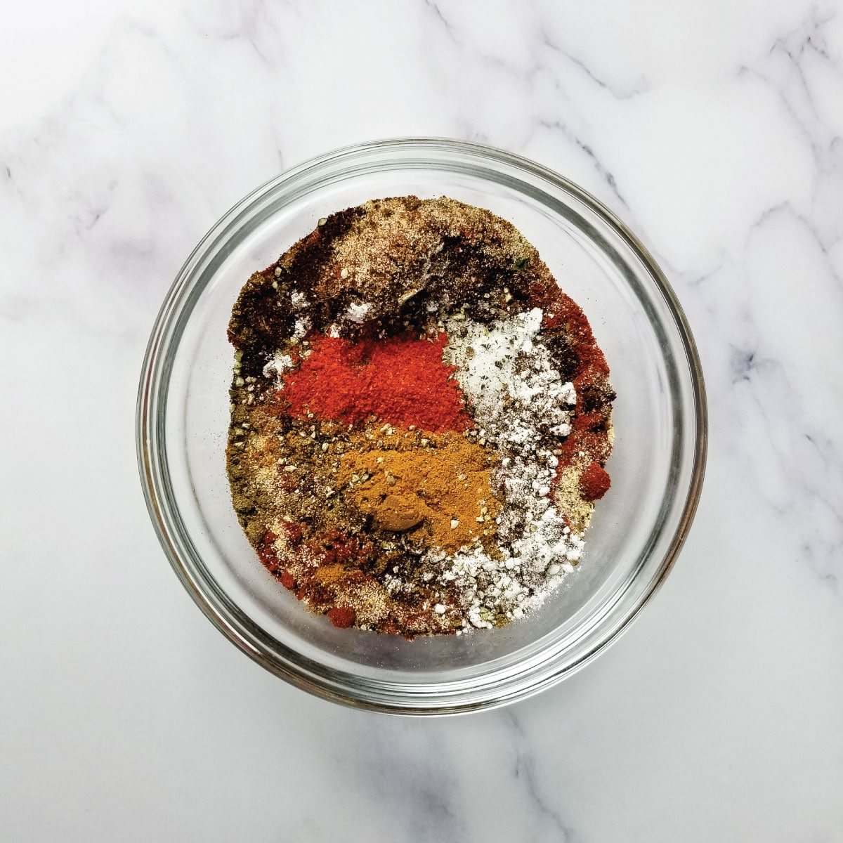 Seasonings for chili in a prep bowl with flour about to be mixed together.