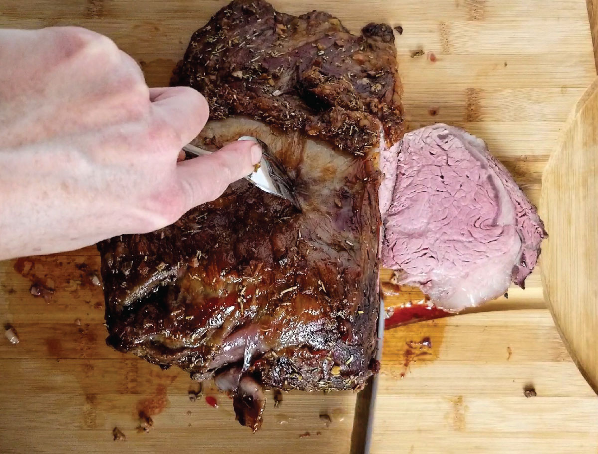 Cutting the roast against the grain on a cutting board.