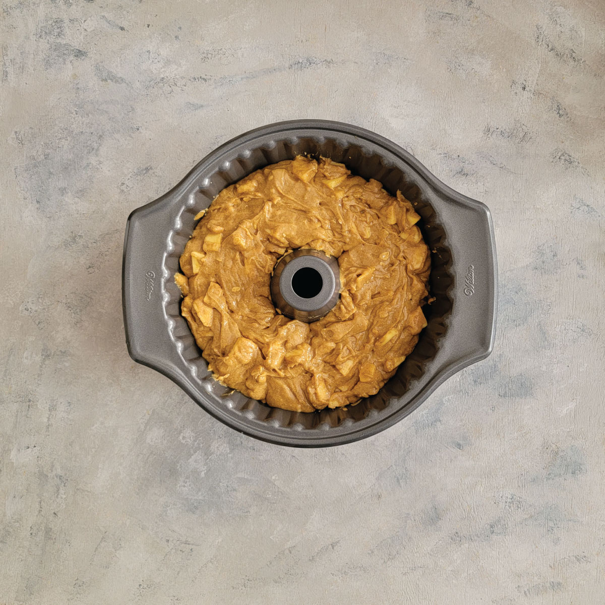 Cake batter in a bundt pan ready to go into the oven.