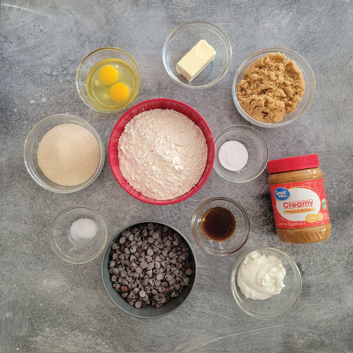 Ingredients for the cookies - butter, brown sugar, baking soda, flour, sugar, salt, chocolate chips, vanilla extract, yogurt and peanut butter.