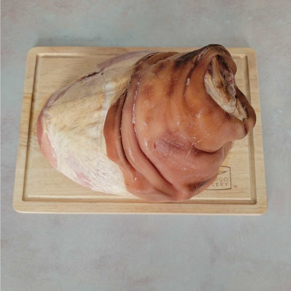Ham on a cutting board ready to remove the skin.