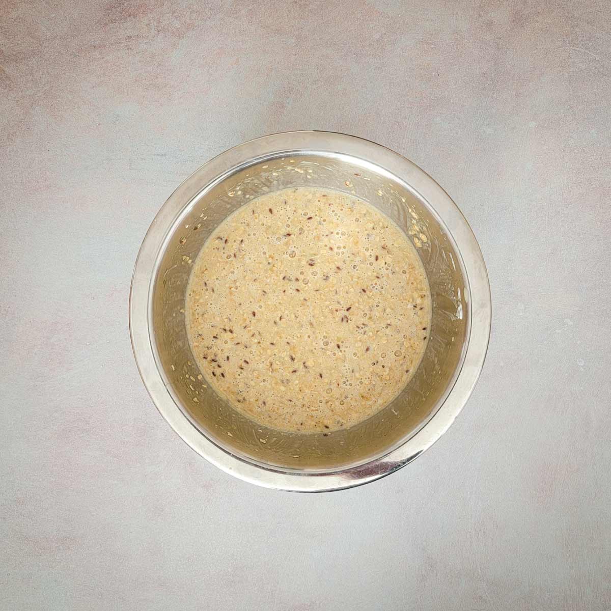 Oatmeal pancake batter in a bowl ready to spoon out on a griddle.