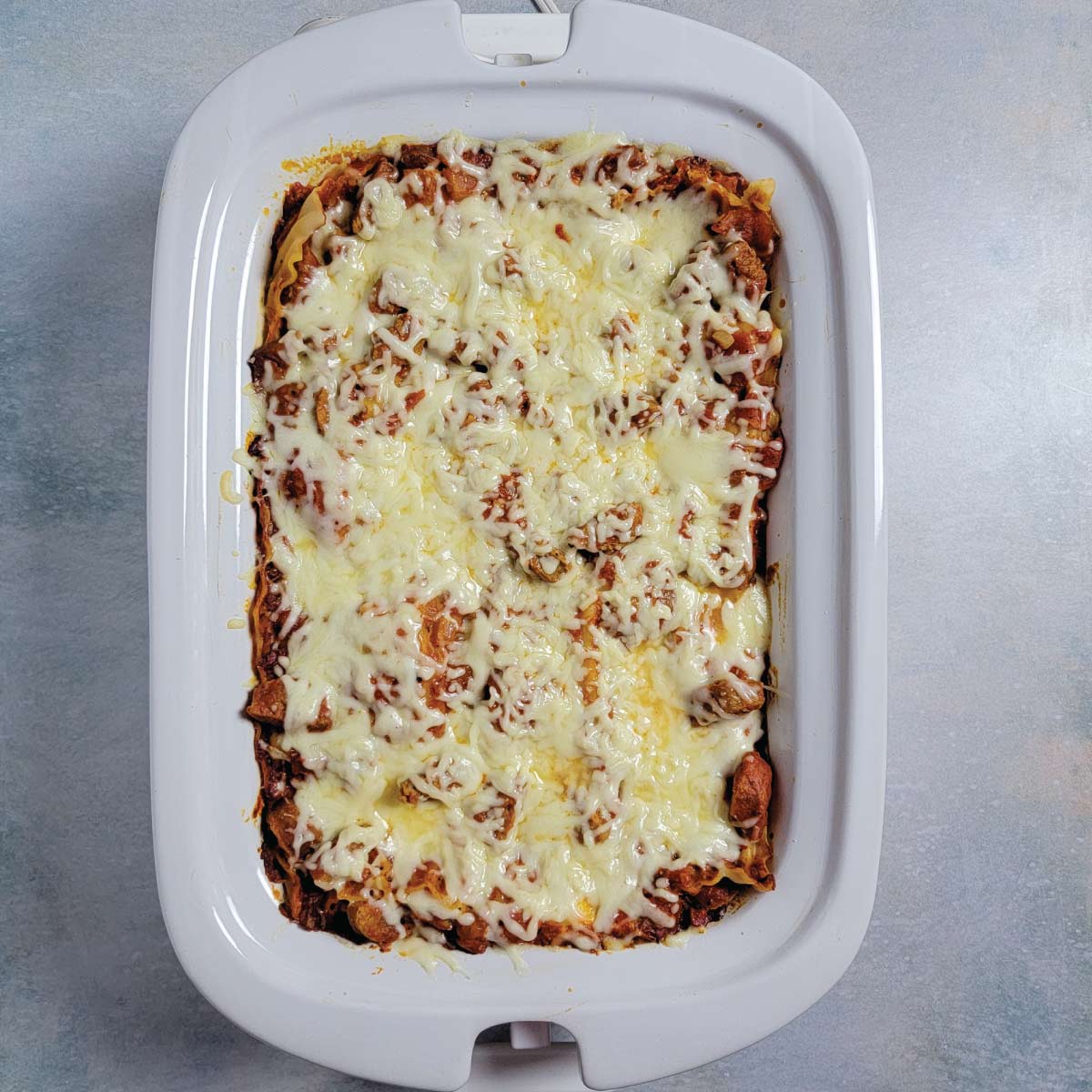 Lasagna in the casserole Crock-Pot resting before cutting.