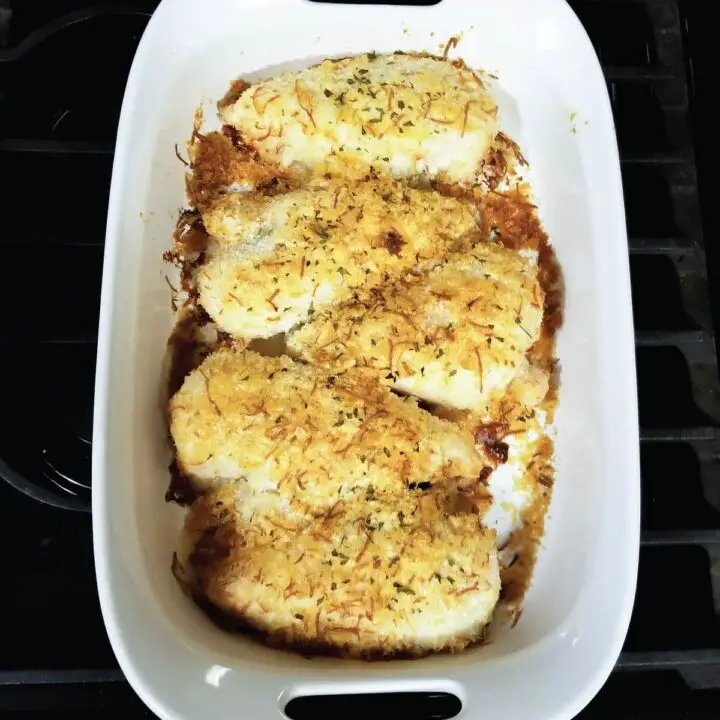 Chicken with a potato and cheese topping in a baking dish resting before serving.