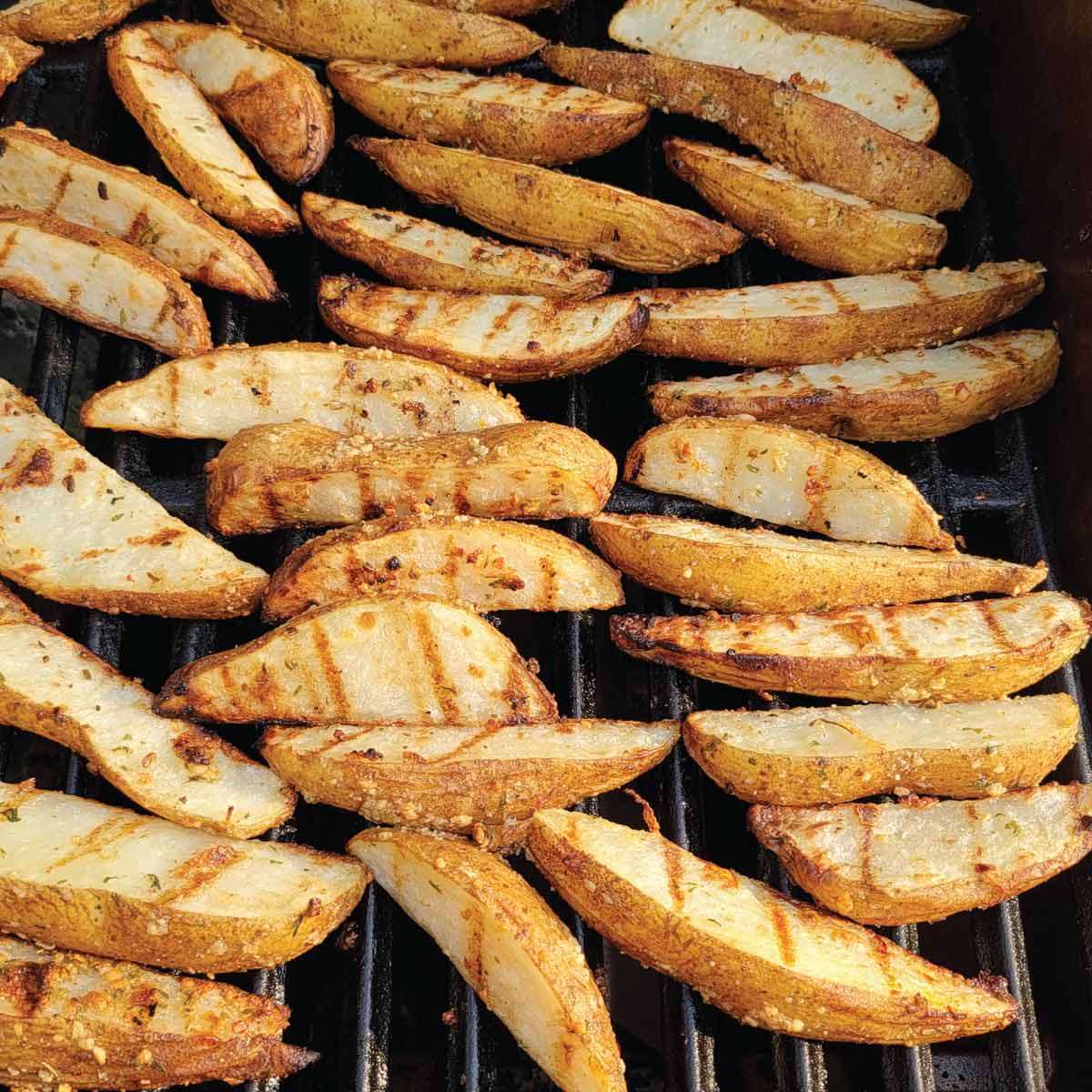 Seasoned wedges on the grill after flipping to cook on the other side.