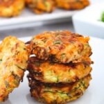 Zucchini fritters stacked on a plate ready to serve.