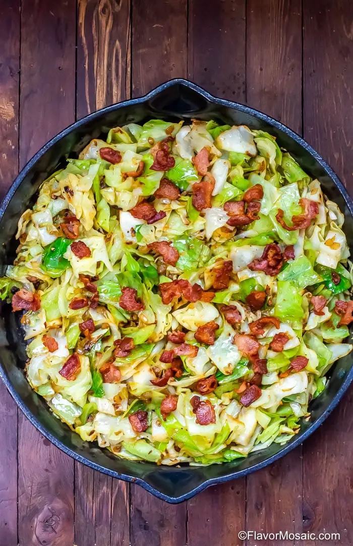 Fried cabbage with bacon in a cast iron skillet ready to serve.