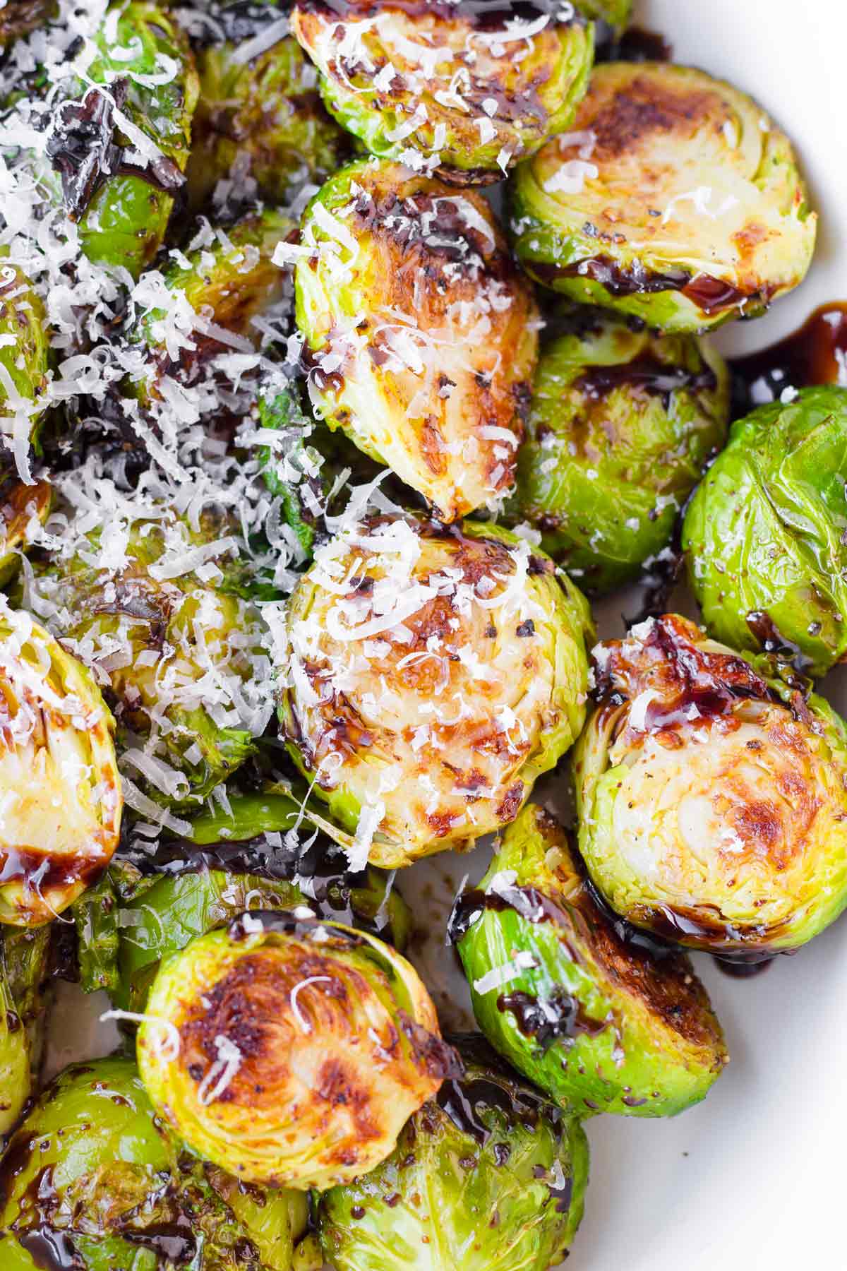 balsamic glazed Brussel sprouts topped with fresh parmesan cheese in a serving dish ready to serve.