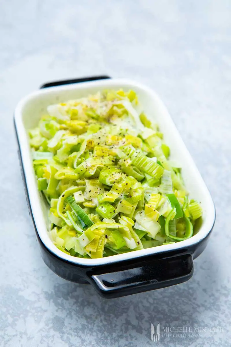Creamed leeks in a baking dish after cooking ready to serve.