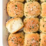 Rolls in the baking dish after cooking, topped with chives and coarse salt.