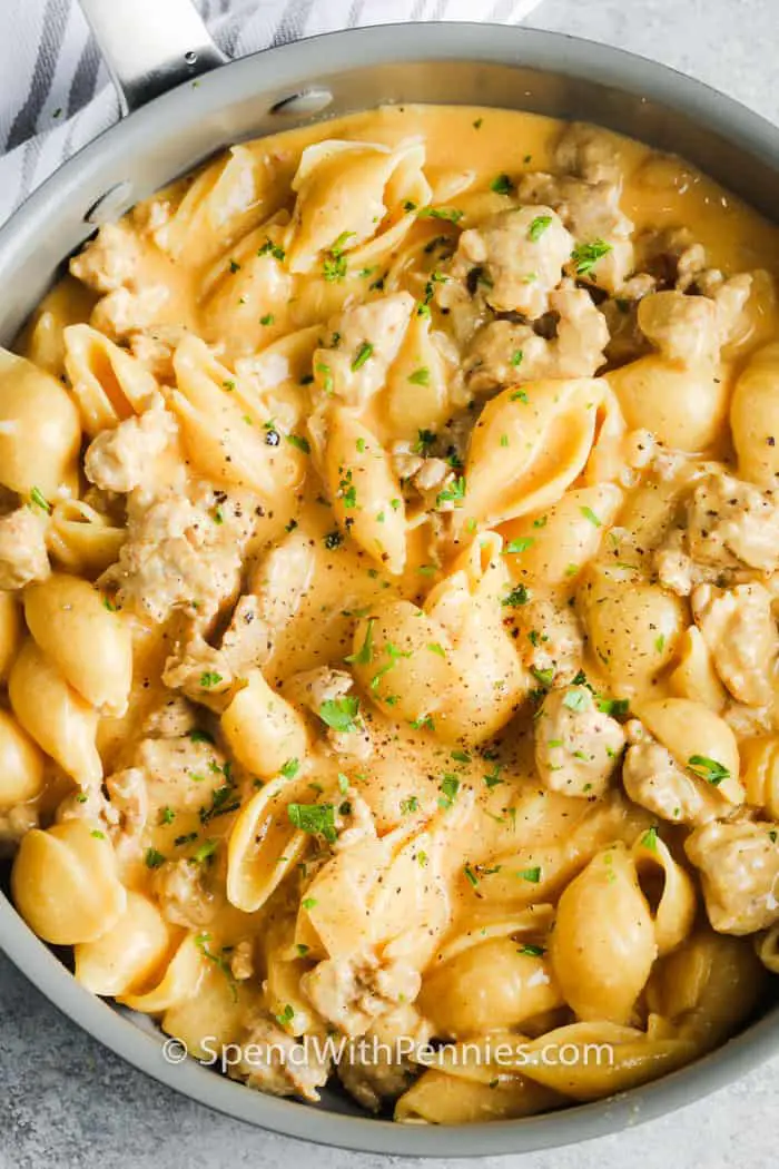 Cheesy ground turkey pasta in a pan garnished with fresh parsley ready to serve.