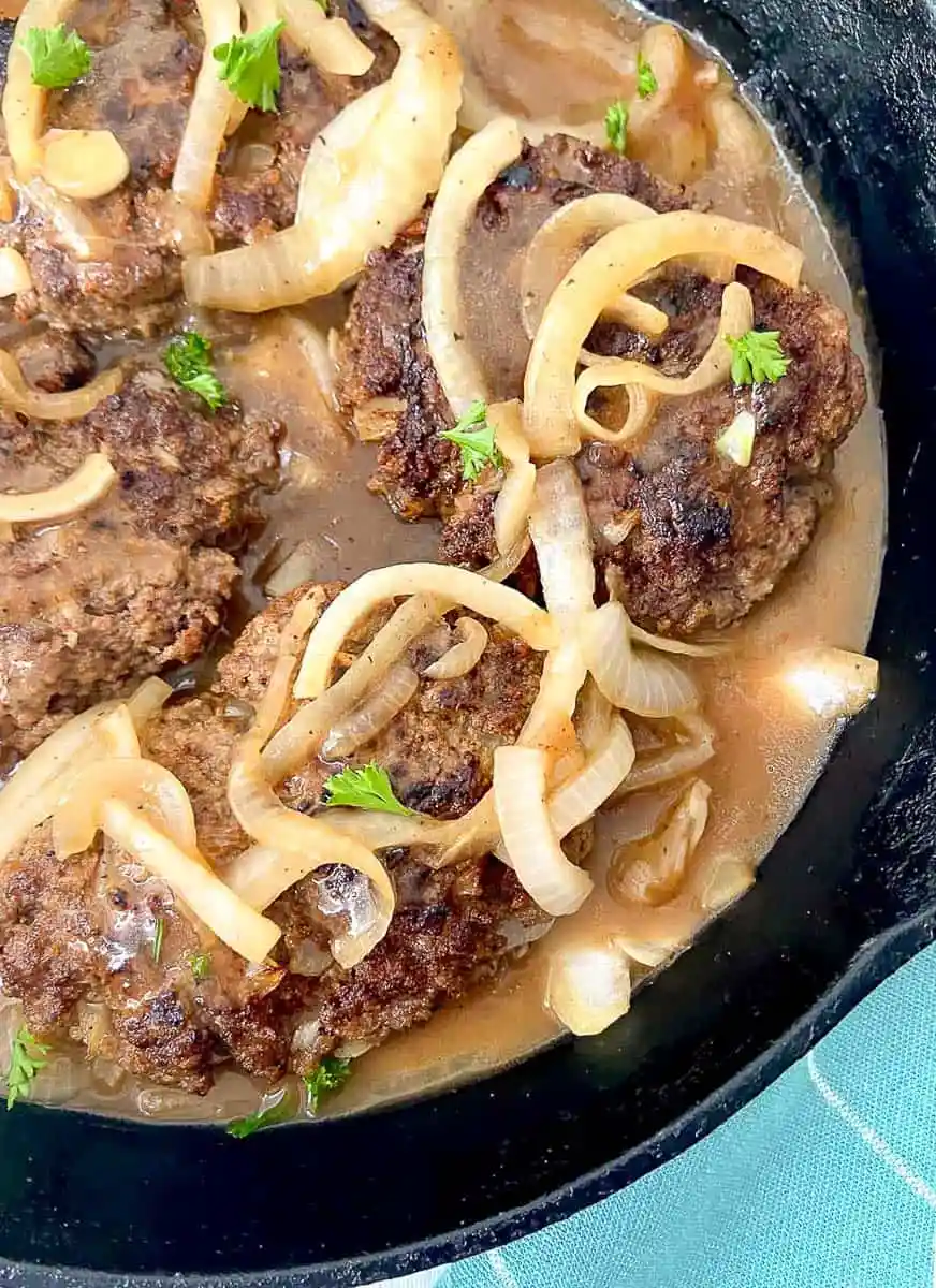 Salisbury steak in a cast iron skillet ready to serve.