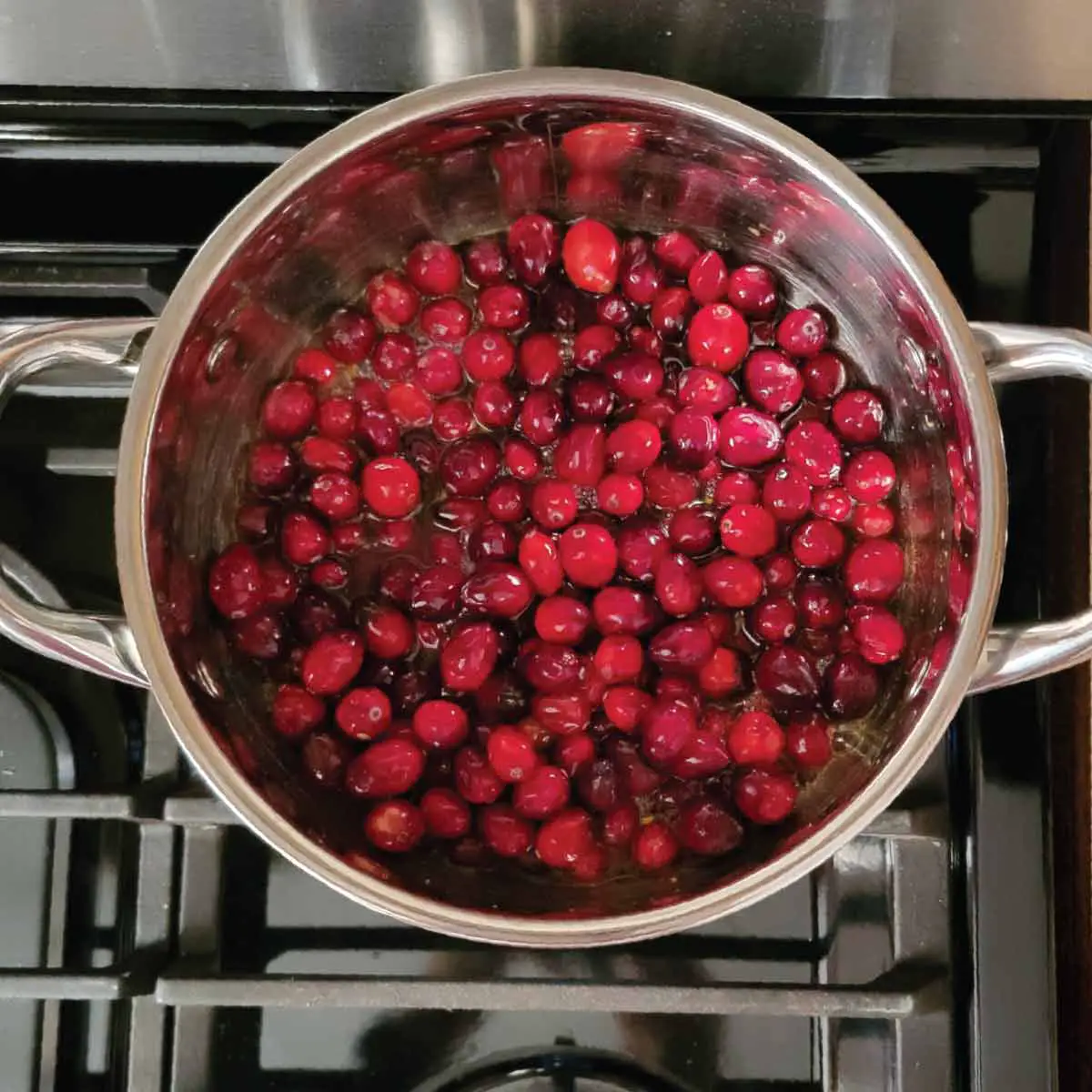 Pot on the stove boiling down the cranberries in the orange juice mixture.