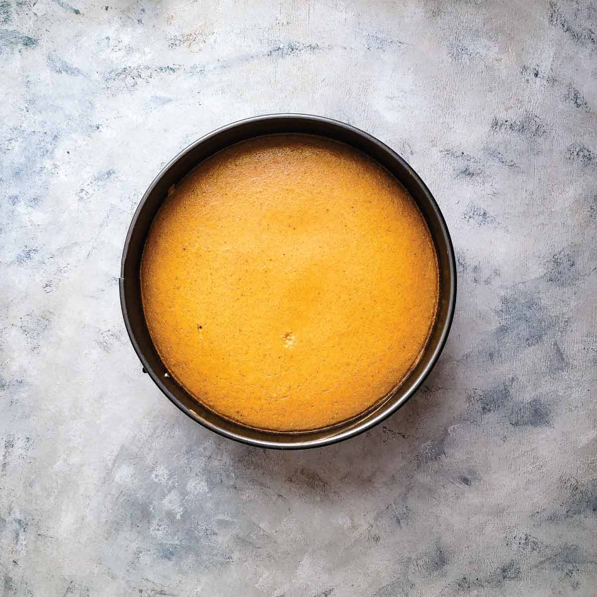 Pumpkin cheesecake out of the oven before cooling down all the way. The edges are slightly darker then the rest of the cheesecake.