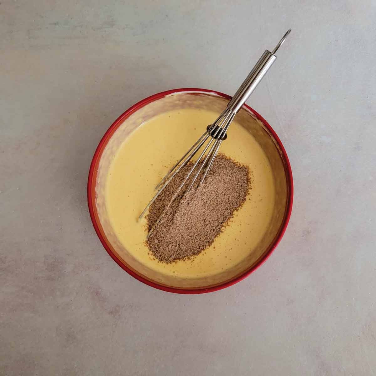 pumpkin, egg and yogurt mixed together in a bowl with the brown sugar, flour and pumpkin pie spice poured over ready to mix in.