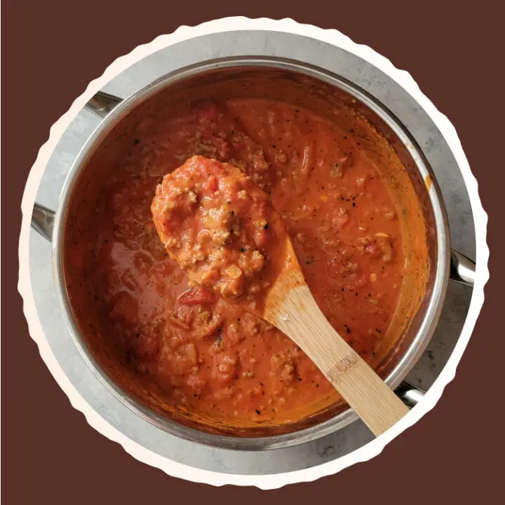 lasagna sauce with sausage in a sauce pot.