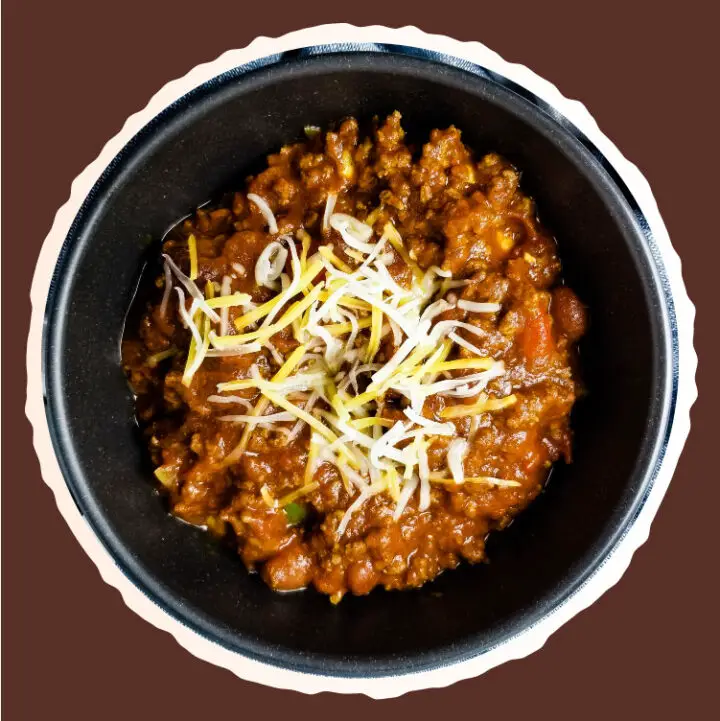 Chili in a bowl topped with shredded cheese ready to eat.