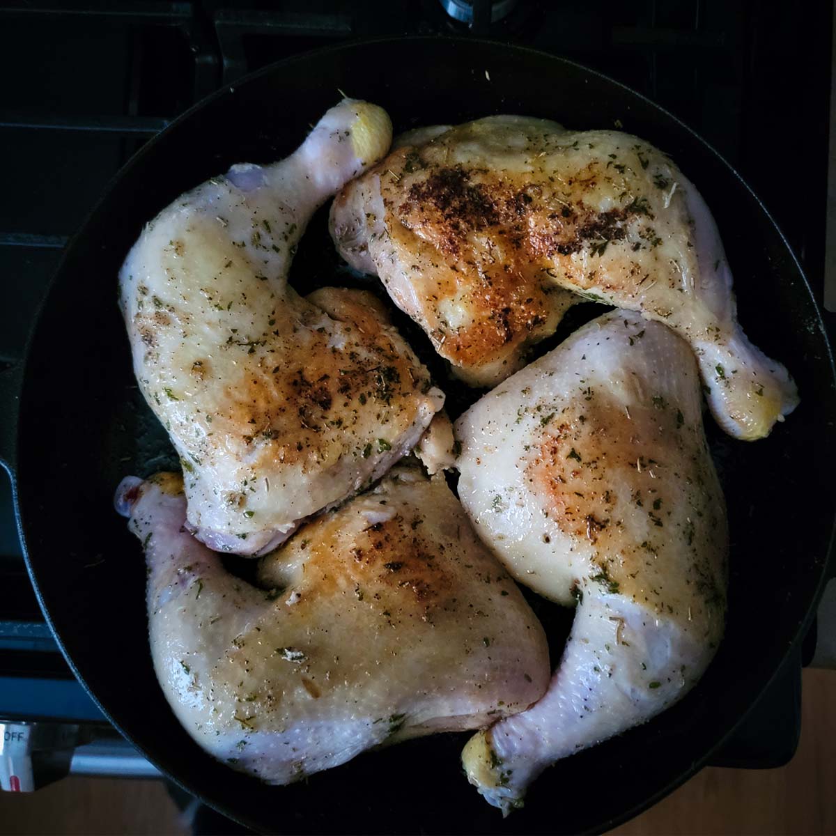 leg quarters in a cast iron pan before going in the oven. The skin was starting to brown so it will get to a golden brown in the oven.